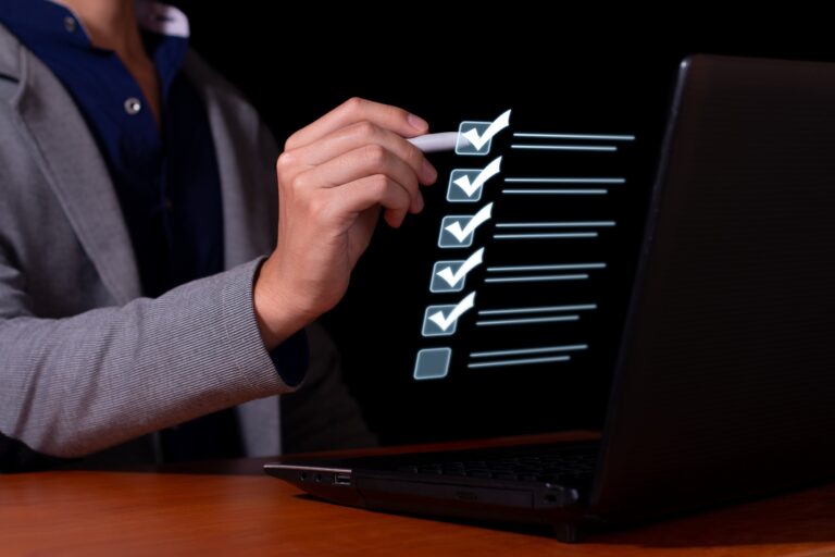 Un homme d'affaires coche la liste de contrôle pour le contrôle des documents, la qualité des produits en ligne et l'homologation commerciale.