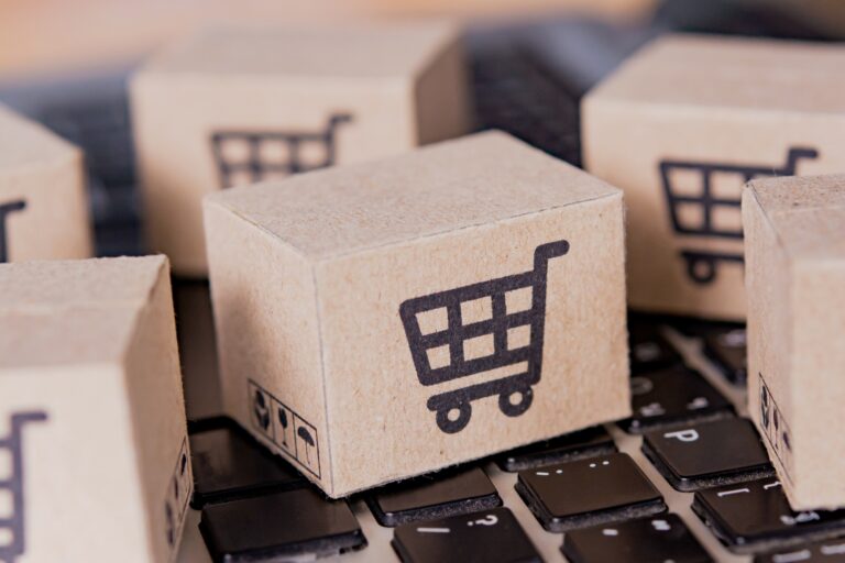 Boîte en carton avec un logo de panier d'achat sur le clavier d'un ordinateur portable.