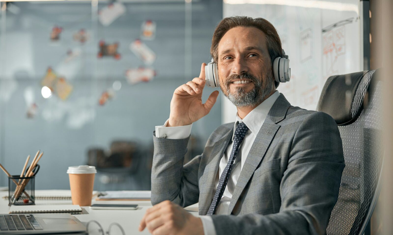 happy-businessman-with-wireless-headphones-listening-educational-webinar