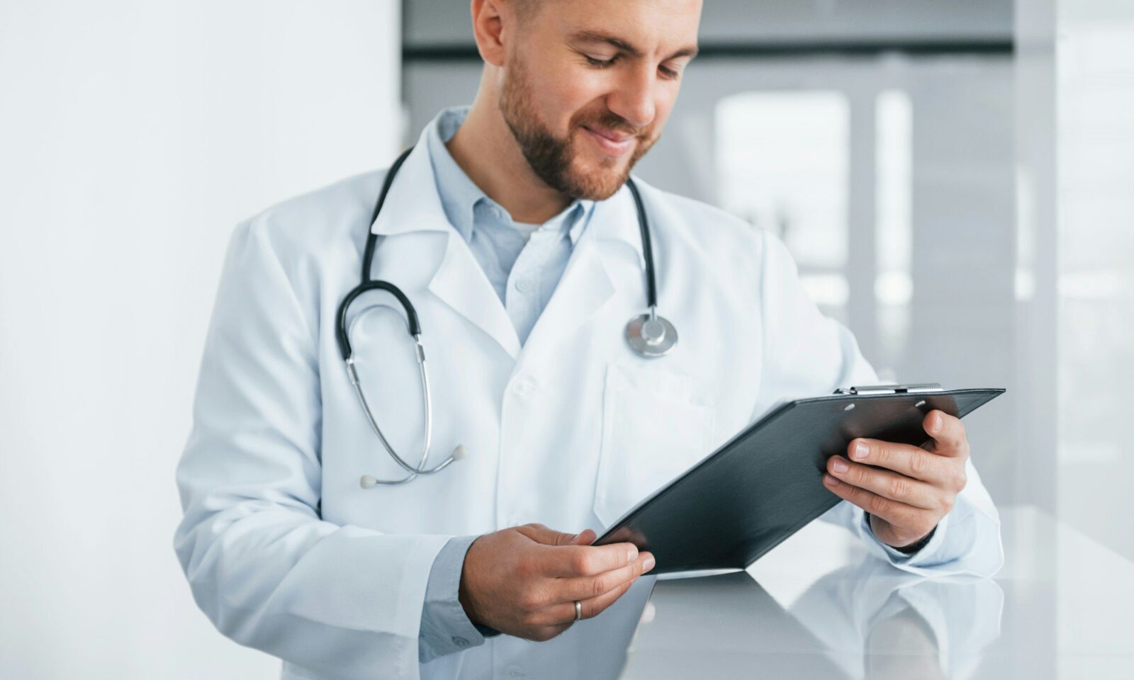 médecin-professionnel-en-blouse-blanche-tenant-un-bloc-notes-dans-la-clinique