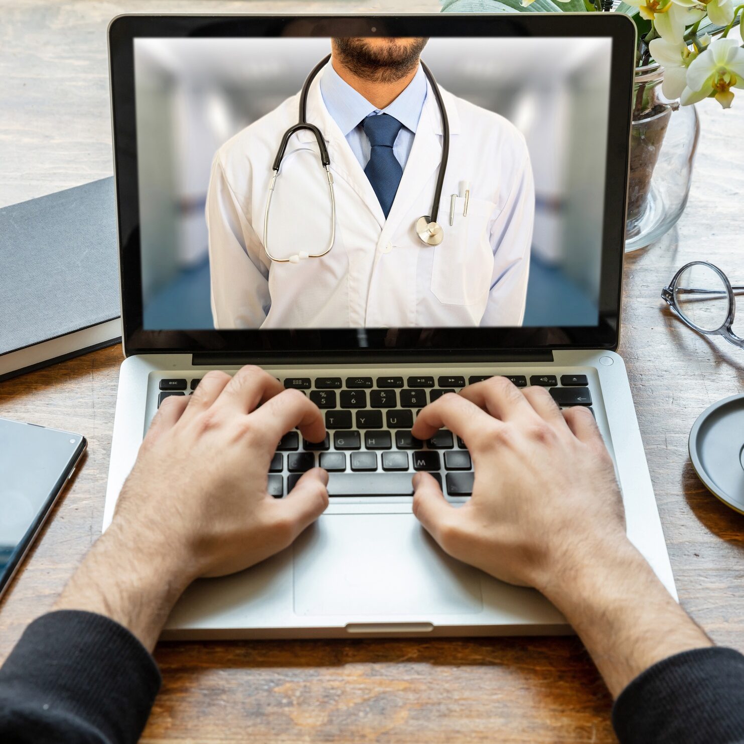 Telemedicine concept. Doctor GP on a computer screen, office desk background