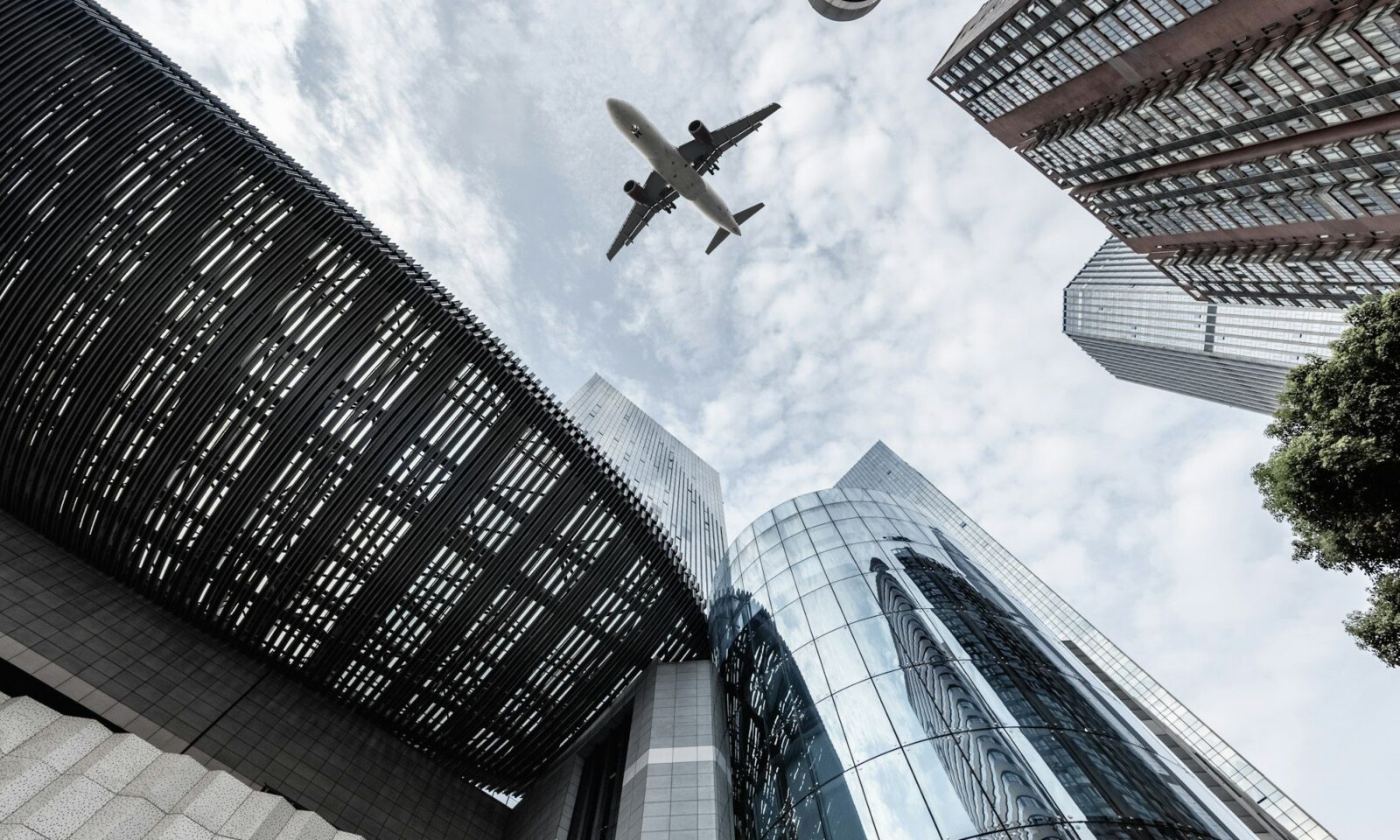 upward-view-of-airplane-and-modern-building